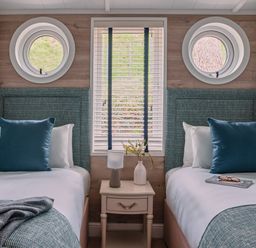 A bedroom with two beds and a window at Milk Wood 2 Spa in Laugharne