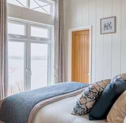 A bedroom with a bed and window at Milk Wood 2 Spa in Laugharne