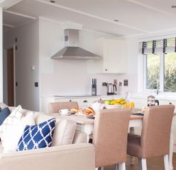 A kitchen with a dining area featuring a table and chairs at Milk Wood 2 Spa Laugharne