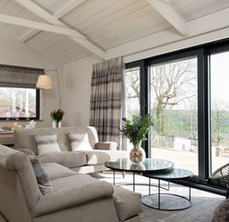 A living room with a sofa and dining table at Dylan Spa in Laugharne