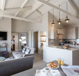 A living room with kitchen area and breakfast items at Dylan Spa in Laugharne