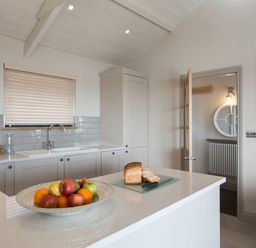 A kitchen with a fruit bowl and bread on the counter at Dylan Spa Laugharne