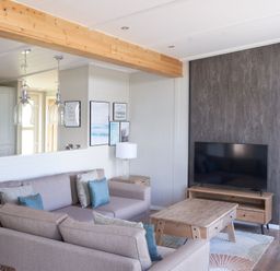 A living room with a sofa and television at Milk Wood 3 in Laugharne