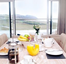 A dining room with a table set for breakfast at Milk Wood 3 in Laugharne