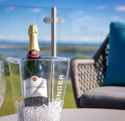 A champagne bottle in an ice bucket with glasses at Apex Spa Laugharne