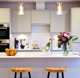 A kitchen with barstools and a fruit bowl at Epic Spa in Laugharne