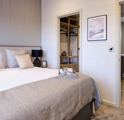 A bedroom with a bed and wardrobe at Epic Spa (Pet) Laugharne