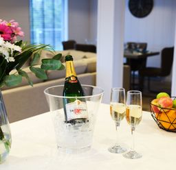 A kitchen with a champagne bottle in an ice bucket and glasses on the counter at Epic Spa (Pet) in Laugharne