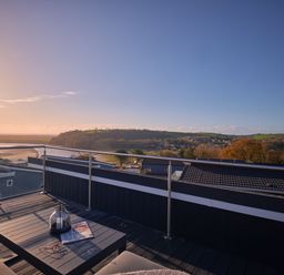 A rooftop terrace with a table and view at Sonnet 3 Roof Terrace Spa in Laugharne