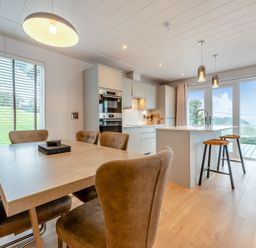 A kitchen with a dining table and chairs at Epic Spa (Roof Terrace) Laugharne