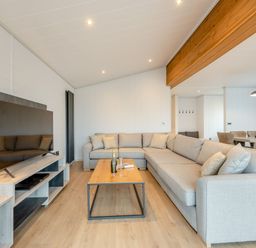 A living room with a sofa and television at Epic Spa (Roof Terrace) Laugharne