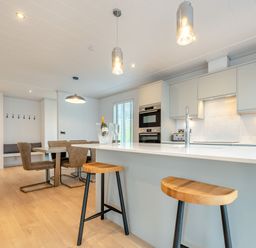 A kitchen with an island and stools at Epic Spa (Roof Terrace) Laugharne