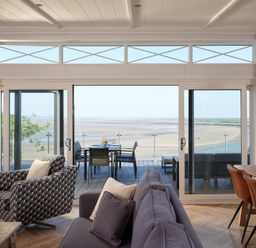 A living room with glass doors leading to a veranda at Canto Spa Laugharne