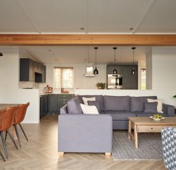 A living room with a sofa and dining area at Canto Spa in Laugharne