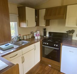 A kitchen with sink and stove at Caravan 1 at Blackmoor Farm near Tenby