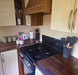 A kitchen with cabinets and stove at Caravan 1 at Blackmoor Farm near Tenby