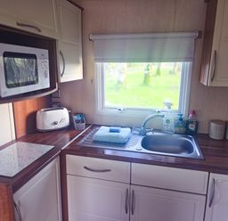 A kitchen with a sink and microwave at Caravan 1 at Blackmoor Farm near Tenby