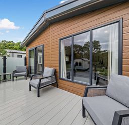 A deck with outdoor furniture and windows at Saron 2.0 Pet in Llandyrnog