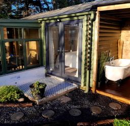 A garden with a doorway and a bathtub at 20 Chatham Log Cabins in Caernarfon