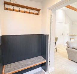 A hallway with a coat rack and bench at Lodge at Nadur