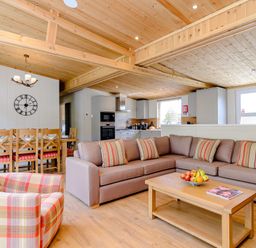 A living room with furniture and a kitchen area at The Fotheringhay in Kings Cliffe