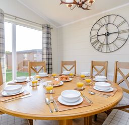 A dining room with a round table set for breakfast at The Folkesworth in Kings Cliffe
