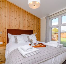 A bedroom with a bed and breakfast items on a tray at The Folkesworth (Pet) in Kings Cliffe