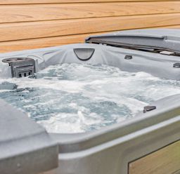 A hot tub with water and jets in an outdoor area at Saron 2.0 Spa Pet, Llandyrnog