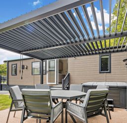 A garden area with seating and a hot tub at Saron 2.0 Spa Pet in Llandyrnog