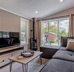 A living room with a sofa and television at Saron 2.0 Spa Pet in Llandyrnog
