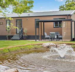 An outdoor area with a house and fountain at Saron 2.0 Pet in Llandyrnog