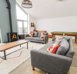 A living room with sofas and a fireplace at Cae Sam in Pentraeth