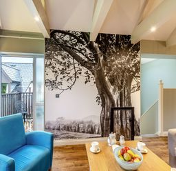 A living room with a door and a wall art at The Whitbarrow Den in Penrith