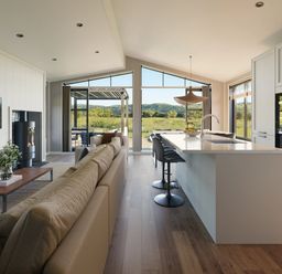 A kitchen with a kitchen island and stools at Fell Side in Penrith