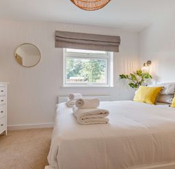 A bedroom with a bed and dresser at Klys 1.0 Spa in Perranporth