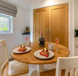 A dining room with food and drinks on a table at Chapel Rock Spa Pet in Perranporth