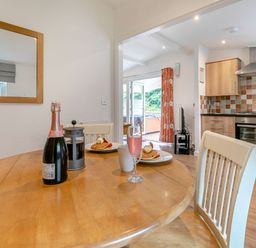 A dining area with a table and chairs at Chapel Rock Spa Pet in Perranporth