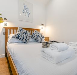 A bedroom with a bed and towels at Droskyn Spa Pet Perranporth