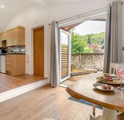 A kitchen with a dining area and an outdoor view at Tremewan Spa Pet Perranporth