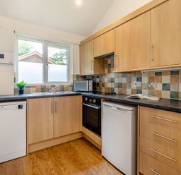 A kitchen with appliances and window at Tremewan Spa Pet Perranporth