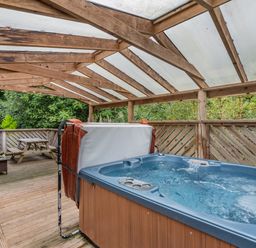 An outdoor area with a hot tub and seating at Poldark Spa Pet in Perranporth