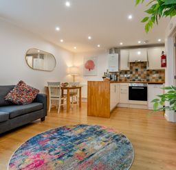 A living room with a sofa and dining area at Poldark Spa Pet Perranporth