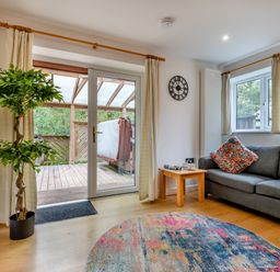 A living room with a sofa and potted plant at Poldark Spa Pet in Perranporth