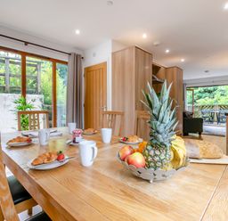 A dining area with a table and fruit bowl at Treehouse Spa in Perranporth