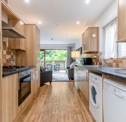A kitchen with appliances and a dining area at Treehouse Spa in Perranporth