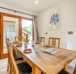 A dining room with a table and chairs at Treehouse Spa in Perranporth