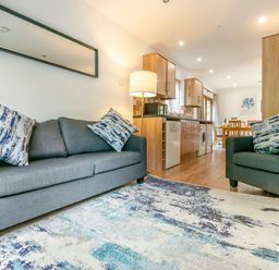 A living room with a sofa and chairs at Treehouse Spa in Perranporth