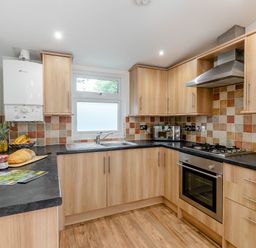 A kitchen with cabinets, sink, oven, and countertop at Morva Spa Pet Perranporth