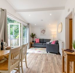 A living room with a dining table and sofa at Morva Spa Pet Perranporth