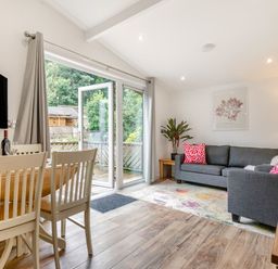 A living room with a sofa and dining area at Morva Spa Pet Perranporth